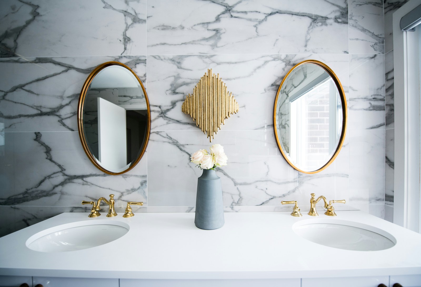 Sparkling clean marble bathroom with gold fixtures — Photo by Christian Mackie on Unsplash